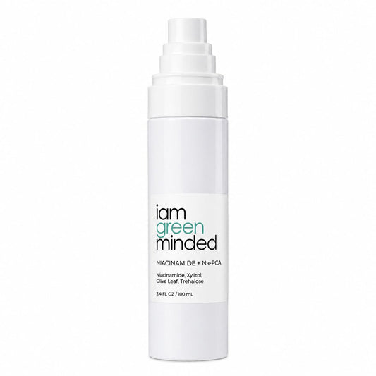 A white cylindrical pump bottle of 'i am green minded' ph spray product on a solid white background. Niacinamide Spray + Na-PCA pH Balancing