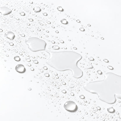 barrier mist droplets and a glossy water streak on a clean white surface, demonstrating a water-like finish