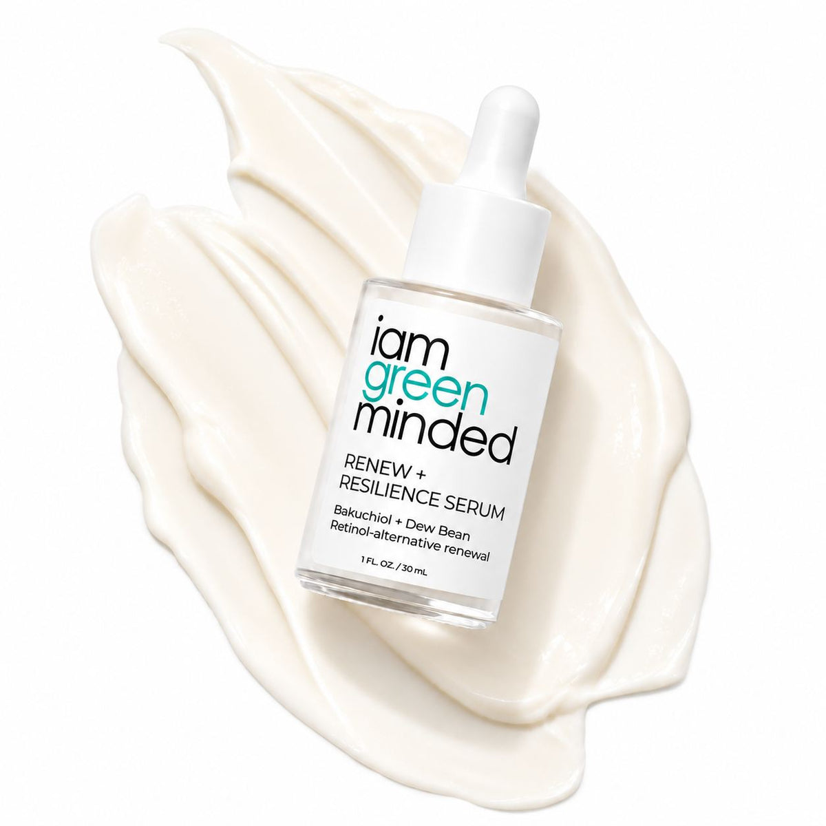 A bottle of iam green minded Renew + Resilience Serum with a white dropper cap, resting on a decorative swirl of creamy off-white serum against a solid white background.