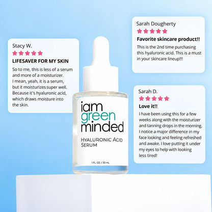 A bottle of iam green minded Hyaluronic Acid Serum centered on a light blue background, with three white review cards showing customer testimonials around it.